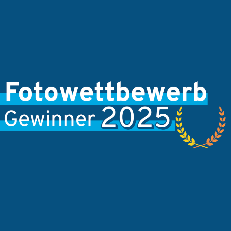 Grafische Darstellung: dunkelblauer Hintergrund, darauf der Text "Fotowettbewerb Gewinner 2025" sowie ein stilisierter Lorbeerkranz