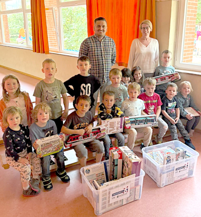 Ein Gruppenbild mit Kita-Kindern, zwei Erwachsenen sowie zwei BahnSpielBoxen